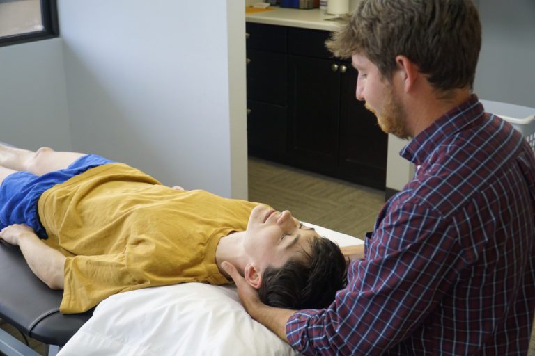 Therapist adjusting patients neck.